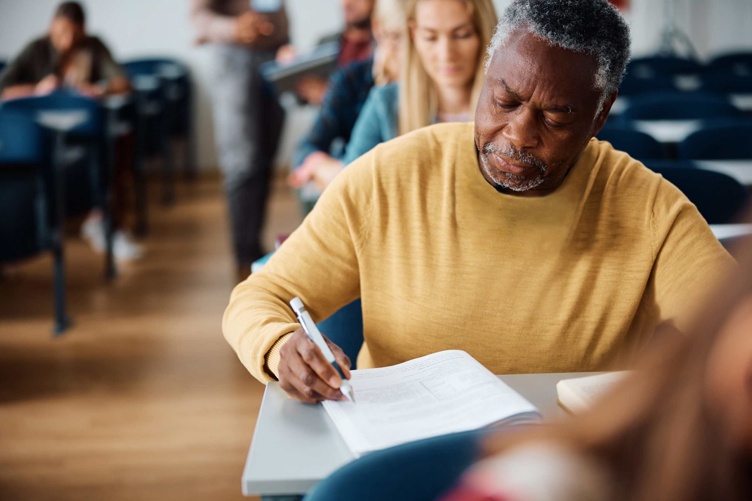 Older man taking a test in a classroom